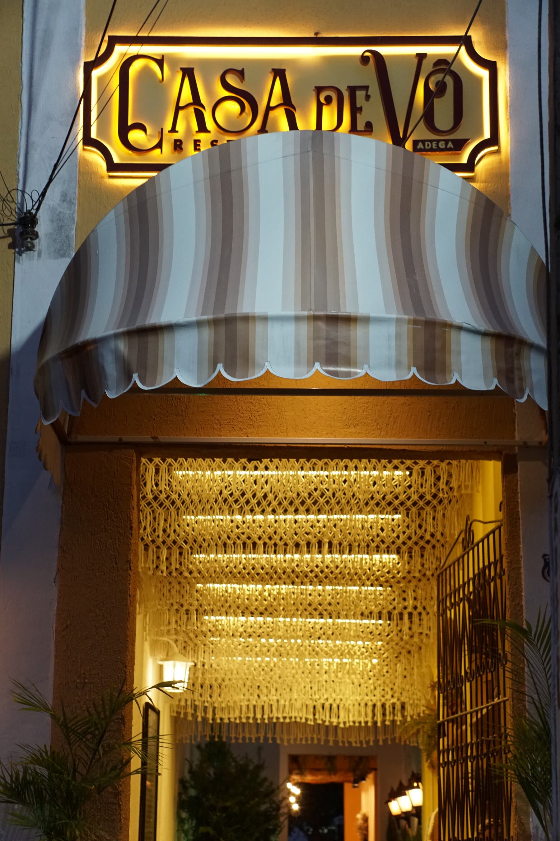 Fachada do Casa de Vô Restaurante & Adega iluminada à noite